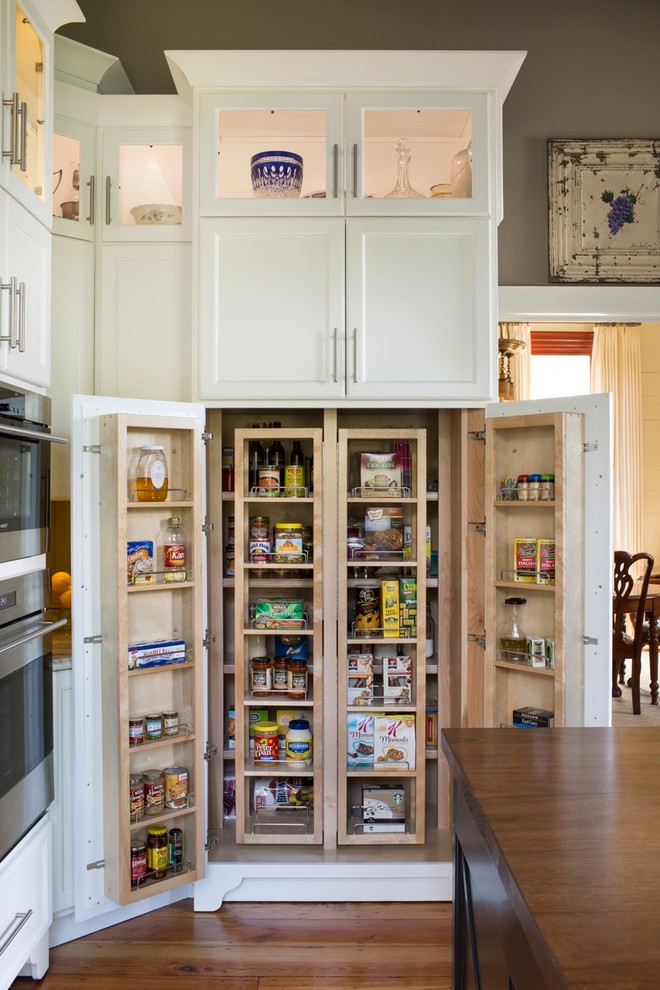 Photo of a large country kitchen pantry in Atlanta with a farmhouse sink, shaker cabinets, white cabinets, limestone benchtops, stainless steel appliances, medium hardwood floors and with island.