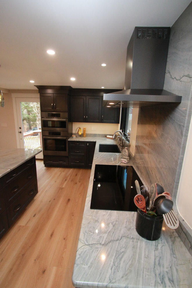 Inspiration for a mid-sized transitional u-shaped laminate floor and brown floor eat-in kitchen remodel in Boston with an undermount sink, shaker cabinets, brown cabinets, quartz countertops, black appliances, an island and multicolored countertops