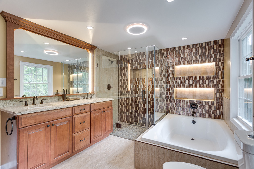 Photo of a large traditional master bathroom in DC Metro with raised-panel cabinets, medium wood cabinets, a corner tub, a corner shower, a two-piece toilet, beige tile, brown tile, ceramic tile, beige walls, bamboo floors, an undermount sink and granite benchtops.