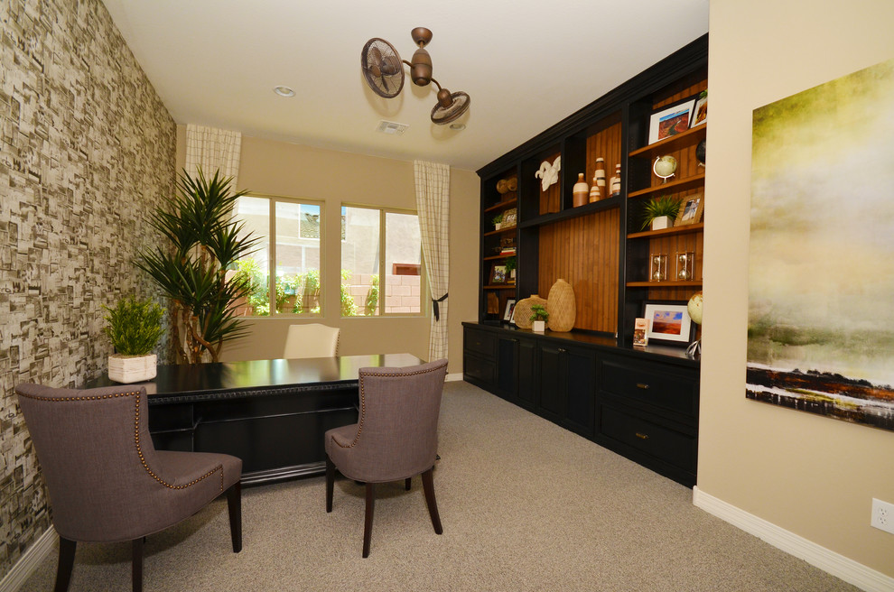 This is an example of a mid-sized mediterranean study room in Phoenix with beige walls, carpet and a freestanding desk.