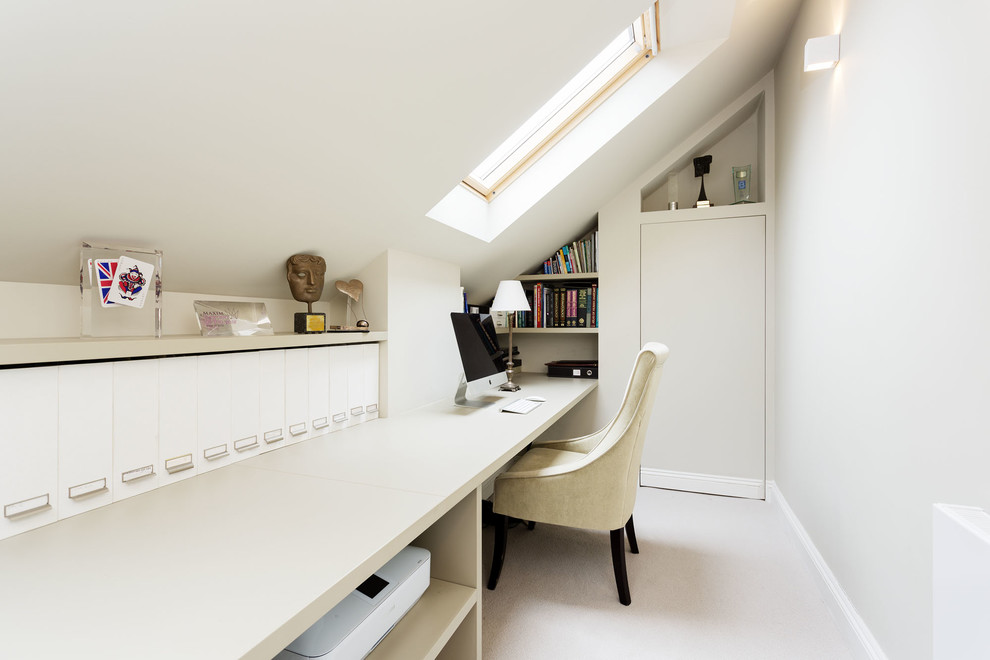 Design ideas for a small modern home office in London with white walls, carpet and a built-in desk.