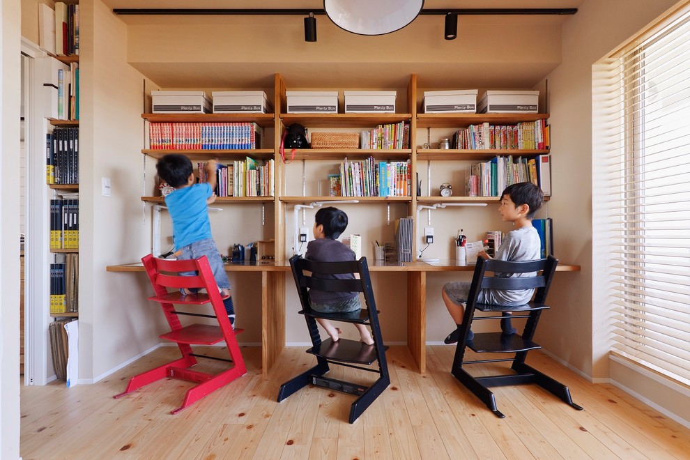 Asian gender-neutral kids' room in Yokohama with beige walls, medium hardwood floors and brown floor.