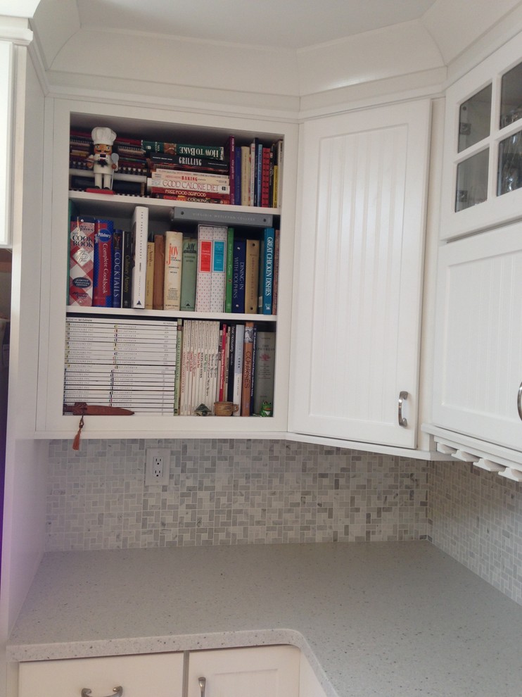 Mid-sized beach style l-shaped eat-in kitchen photo with an undermount sink, beaded inset cabinets, white cabinets, solid surface countertops, gray backsplash, mosaic tile backsplash, white appliances and a peninsula