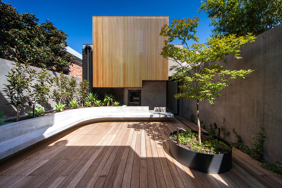 Contemporary backyard deck in Melbourne with a container garden and no cover.
