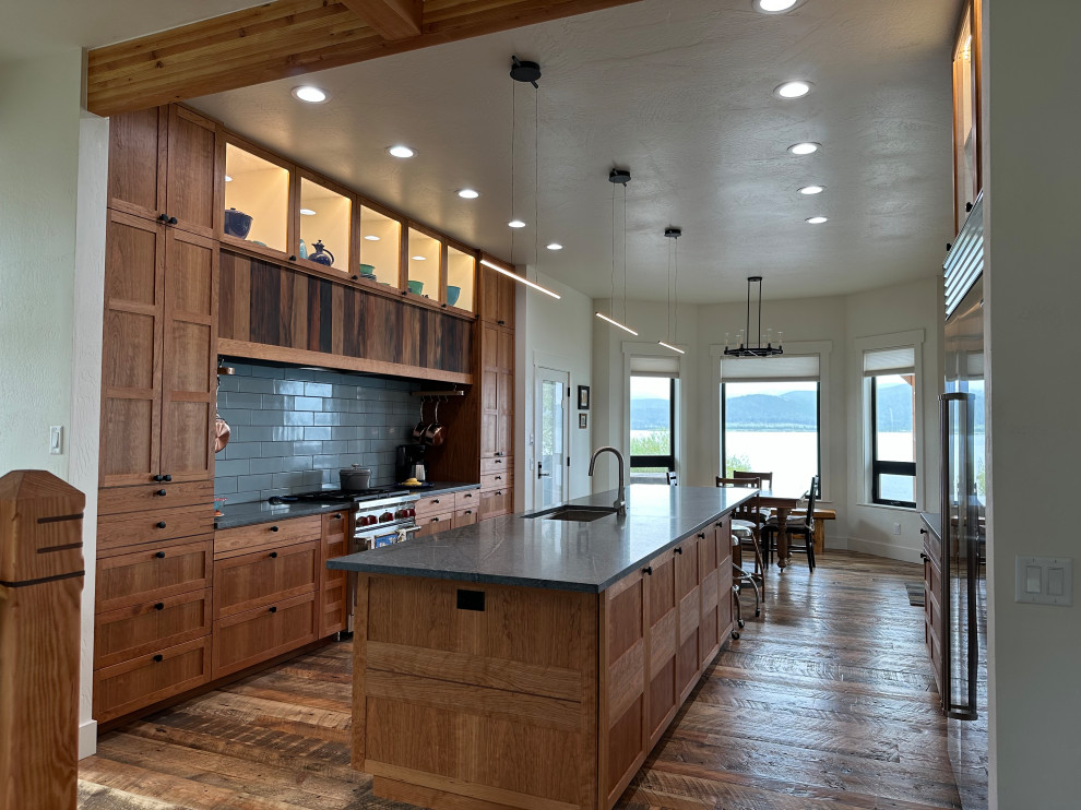 Inspiration for a large beach style eat-in kitchen in Other with an undermount sink, shaker cabinets, medium wood cabinets, soapstone benchtops, blue splashback, porcelain splashback, stainless steel appliances, medium hardwood floors, with island, multi-coloured floor and blue benchtop.