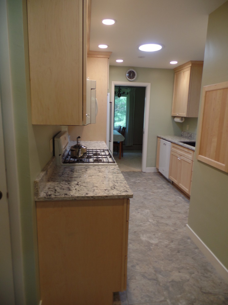 Example of a mid-sized transitional galley vinyl floor eat-in kitchen design in Cedar Rapids with an undermount sink, shaker cabinets, light wood cabinets, quartz countertops, white appliances and no island