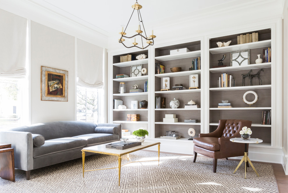 Inspiration for a traditional living room in Houston with a library and light hardwood floors.