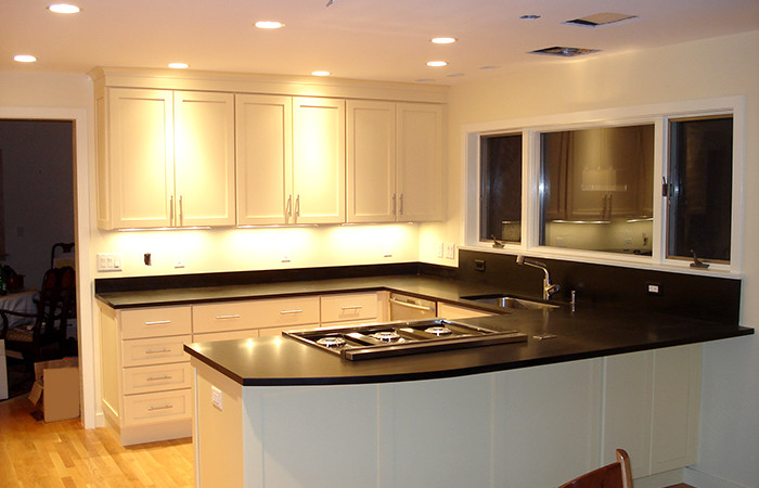 Transitional light wood floor kitchen photo in Boston with no island, white cabinets, an undermount sink and stainless steel appliances