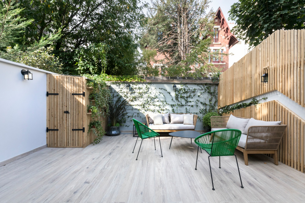 This is an example of a contemporary backyard deck in Paris with no cover.