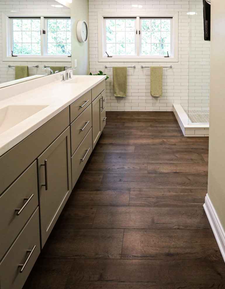 Inspiration for a mid-sized transitional master bathroom in Cleveland with flat-panel cabinets, grey cabinets, a corner shower, a two-piece toilet, white tile, green walls, laminate floors, an integrated sink, solid surface benchtops, blue floor, an open shower, beige benchtops, a double vanity and a freestanding vanity.