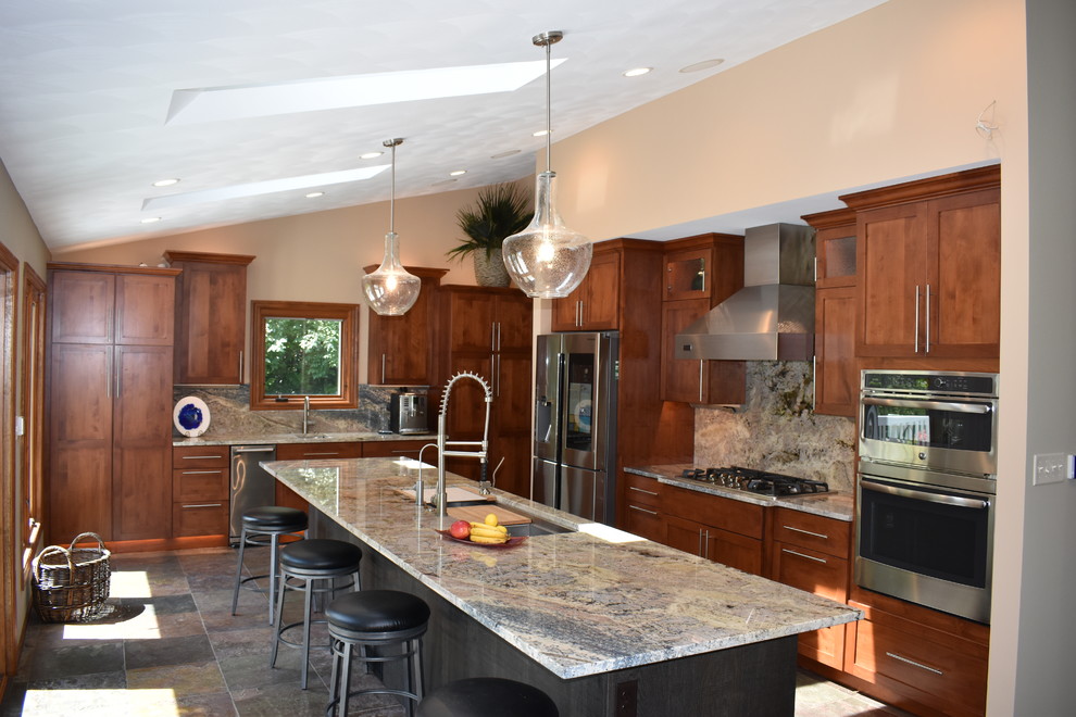 Example of a large trendy galley slate floor eat-in kitchen design with an undermount sink, flat-panel cabinets, granite countertops, stainless steel appliances and an island