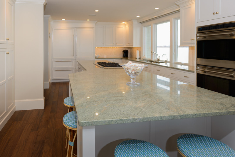Kitchen - transitional medium tone wood floor kitchen idea in Boston with a triple-bowl sink, recessed-panel cabinets, white cabinets, granite countertops, white backsplash, mosaic tile backsplash, stainless steel appliances and an island