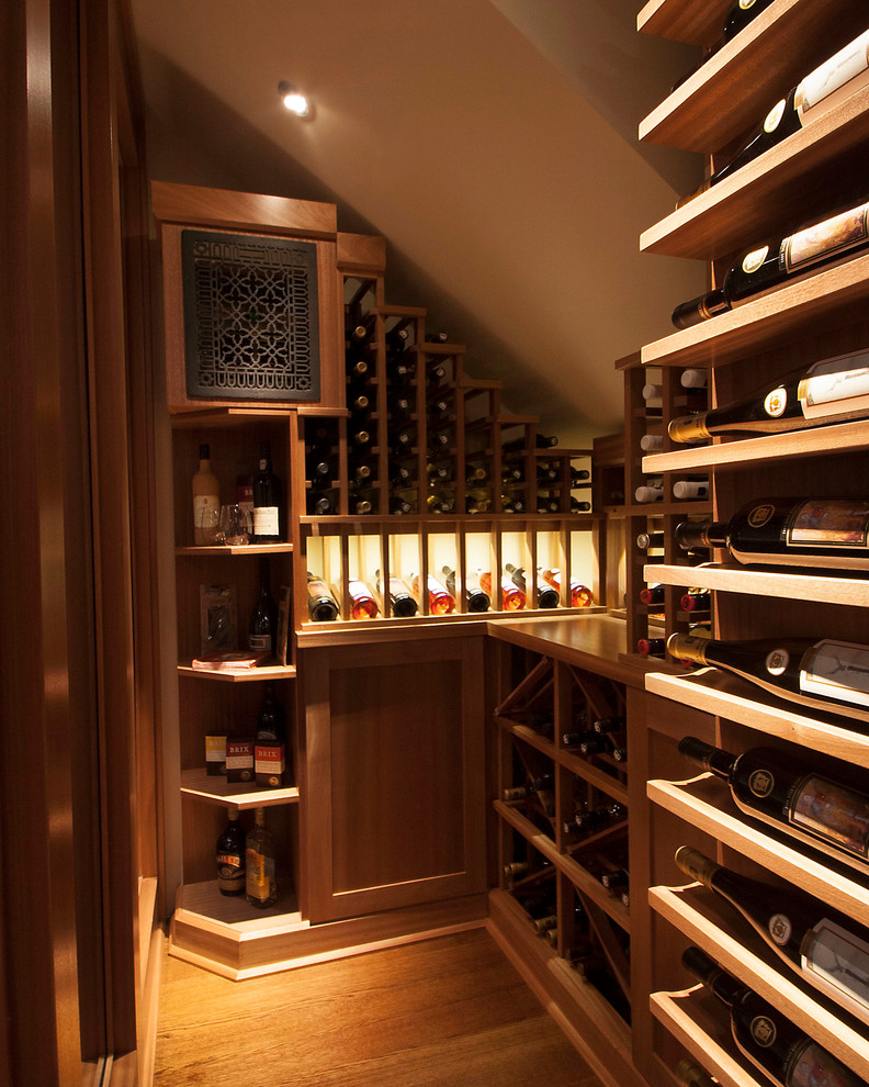 Photo of a transitional wine cellar in Toronto with medium hardwood floors and display racks.