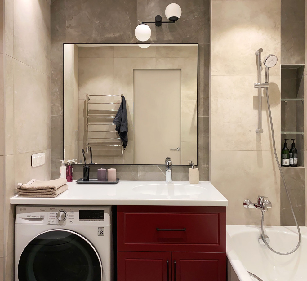 Пример оригинального дизайна: ванная комната в современном стиле с фасадами с выступающей филенкой, красными фасадами, полновстраиваемой ванной, бежевой плиткой, керамогранитной плиткой, столешницей из искусственного камня, белой столешницей, тумбой под одну раковину и напольной тумбой