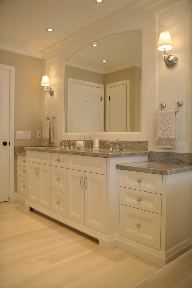 This is an example of a mid-sized traditional master bathroom in Toronto with white walls, light hardwood floors, an undermount sink, recessed-panel cabinets, white cabinets, a freestanding tub and granite benchtops.