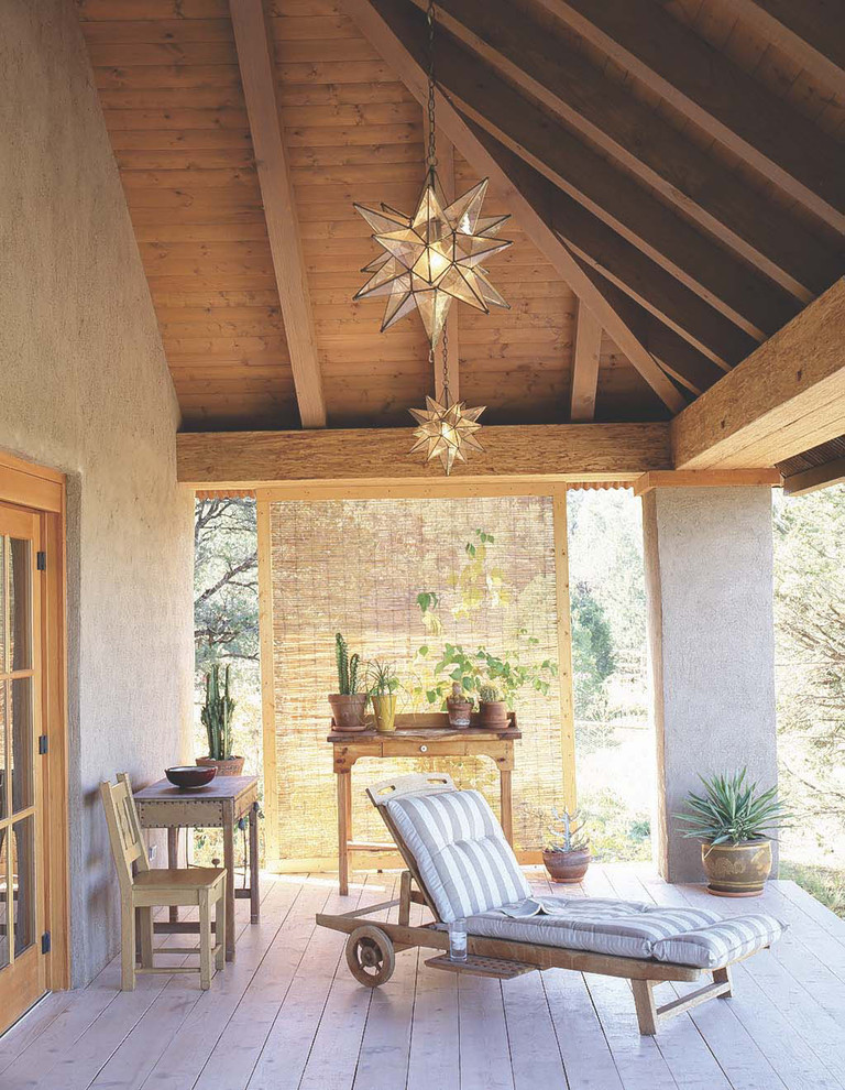 This is an example of a mid-sized southwestern front porch design in Albuquerque with decking and a roof extension.