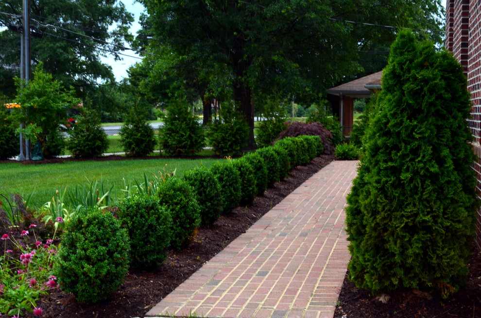 Design ideas for a traditional front yard garden in DC Metro with a garden path and brick pavers.