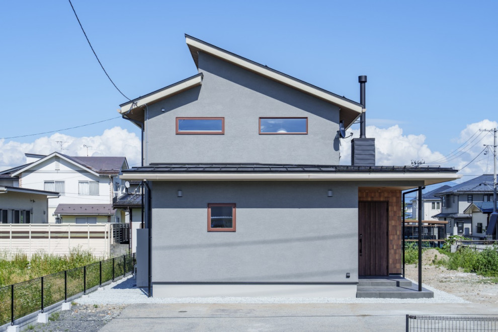 Photo of a mid-sized asian two-storey grey house exterior in Other with a gambrel roof, a metal roof and a black roof.