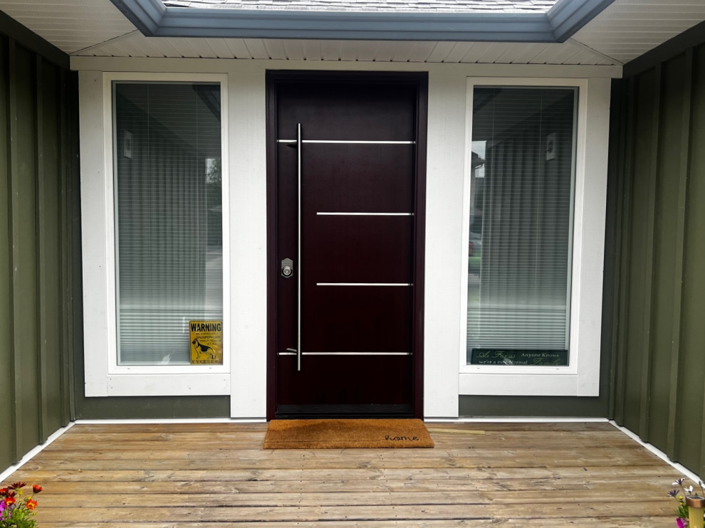 Immagine di una porta d'ingresso minimalista di medie dimensioni con pareti verdi, una porta singola, una porta in legno scuro e pavimento marrone