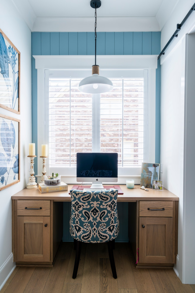 Idee per un piccolo studio stile marino con pareti blu, nessun camino, scrivania incassata e pavimento marrone