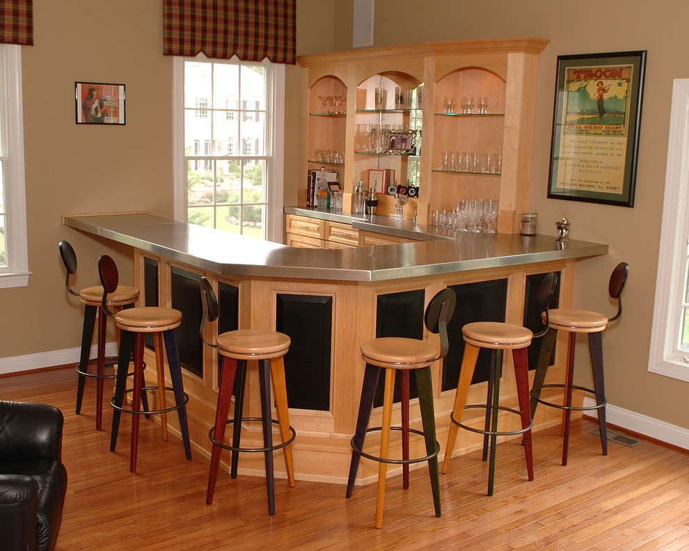 Design ideas for a mid-sized contemporary u-shaped seated home bar in Philadelphia with raised-panel cabinets, light wood cabinets, stainless steel benchtops, light hardwood floors and brown floor.