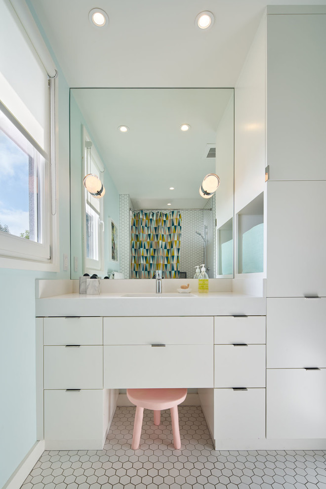 This is an example of a midcentury bathroom in San Francisco with flat-panel cabinets, white cabinets, white tile, white walls and an undermount sink.