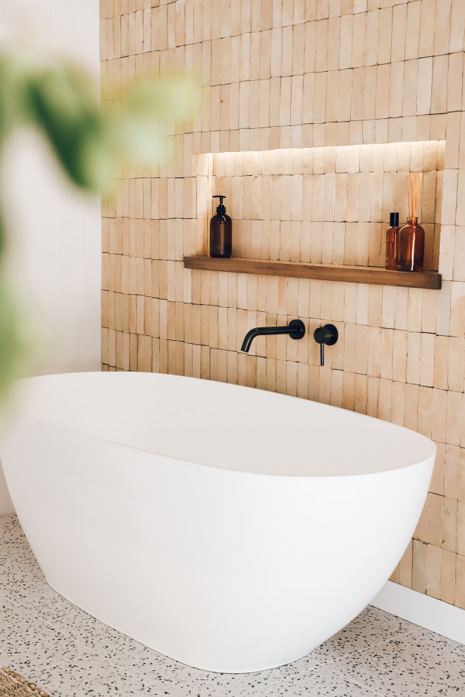 This is an example of a country bathroom in Gold Coast - Tweed with a freestanding tub, beige tile, terra-cotta tile, terrazzo floors, wood benchtops, white floor, a sliding shower screen and a double vanity.