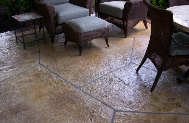 Inspiration for a mid-sized backyard stamped concrete patio remodel in Denver with a roof extension