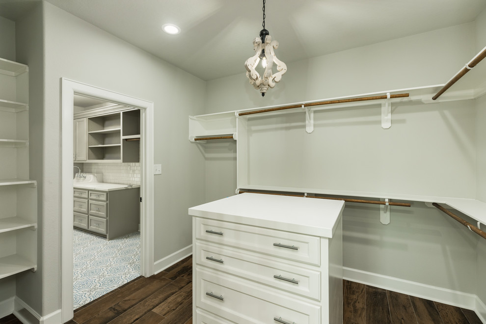 Inspiration for a large country gender-neutral dressing room in Houston with recessed-panel cabinets, white cabinets, porcelain floors and brown floor.