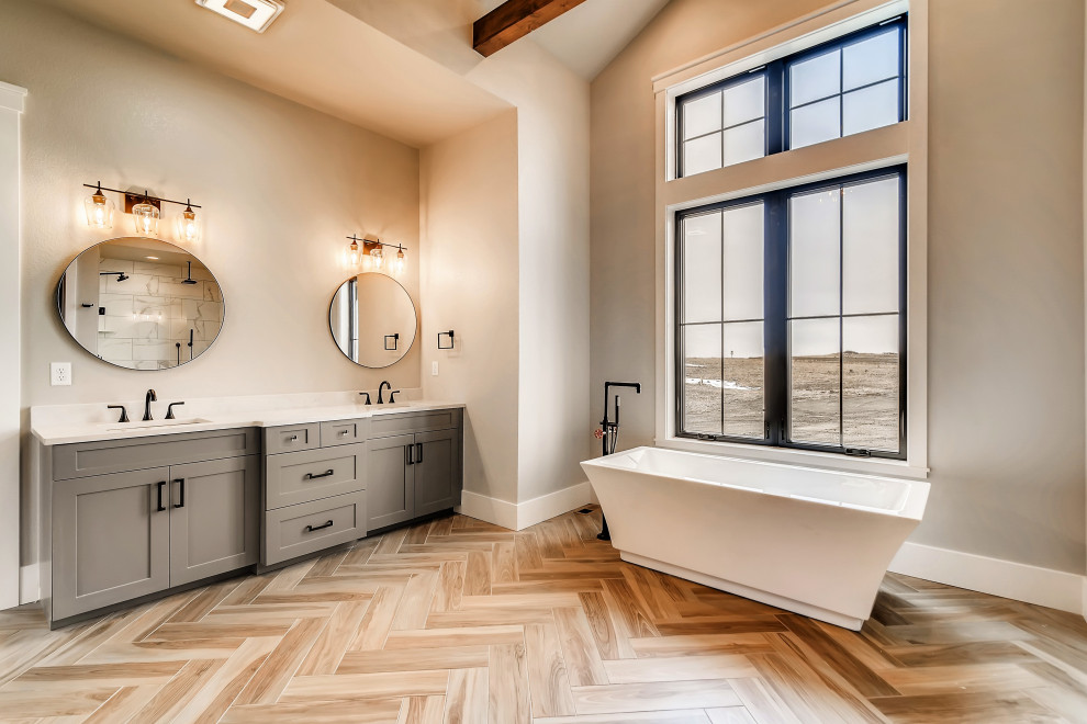 Exempel på ett stort lantligt vit vitt en-suite badrum, med skåp i shakerstil, grå skåp, ett fristående badkar, en kantlös dusch, vit kakel, stenhäll, grå väggar, klinkergolv i porslin, ett undermonterad handfat, bänkskiva i kvartsit, beiget golv och dusch med gångjärnsdörr