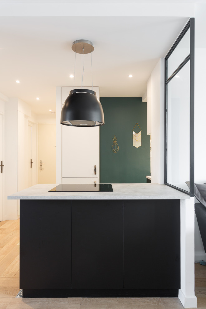 Photo of a mid-sized contemporary u-shaped open plan kitchen in Other with a drop-in sink, flat-panel cabinets, black cabinets, marble benchtops, white splashback, subway tile splashback, panelled appliances, cement tiles, a peninsula, grey floor and white benchtop.
