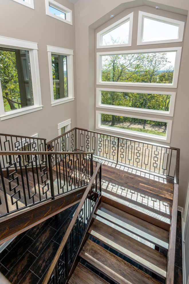 Photo of a large contemporary metal floating staircase in Nashville with open risers and mixed railing.