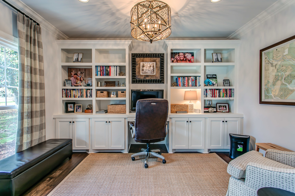 Traditional study room in Nashville with white walls, dark hardwood floors, a built-in desk and brown floor.