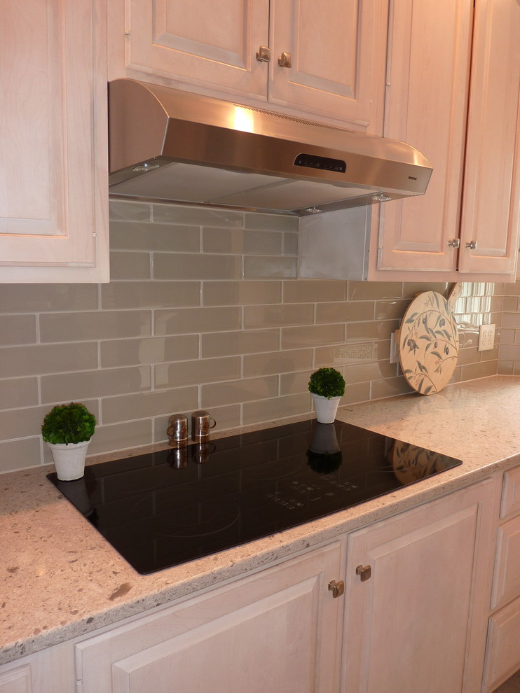 Large transitional l-shaped ceramic tile eat-in kitchen photo with an undermount sink, raised-panel cabinets, light wood cabinets, quartzite countertops, beige backsplash, glass tile backsplash, stainless steel appliances and an island