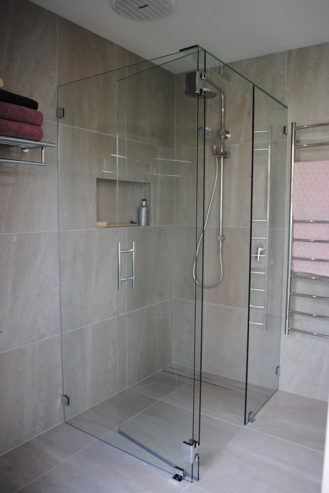 Large contemporary master bathroom with flat-panel cabinets, grey cabinets, a corner shower, a one-piece toilet, gray tile, ceramic tile, grey walls, ceramic floors, a vessel sink, solid surface benchtops, grey floor, a hinged shower door and white benchtops.