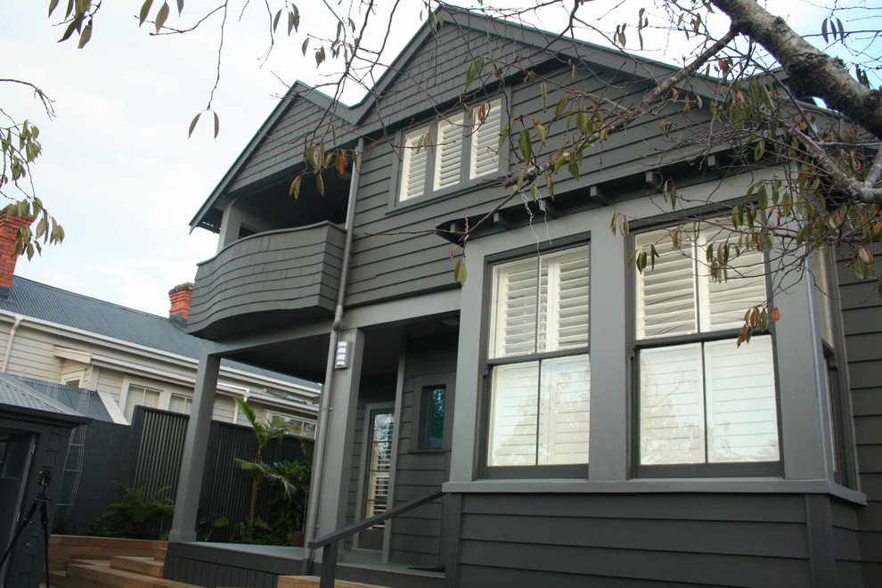 Mid-sized transitional two-storey grey exterior in Auckland with wood siding.