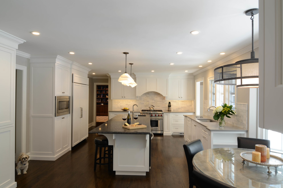 Mid-sized contemporary u-shaped separate kitchen in New York with an undermount sink, shaker cabinets, white cabinets, quartz benchtops, white splashback, marble splashback, stainless steel appliances, dark hardwood floors, with island and brown floor.