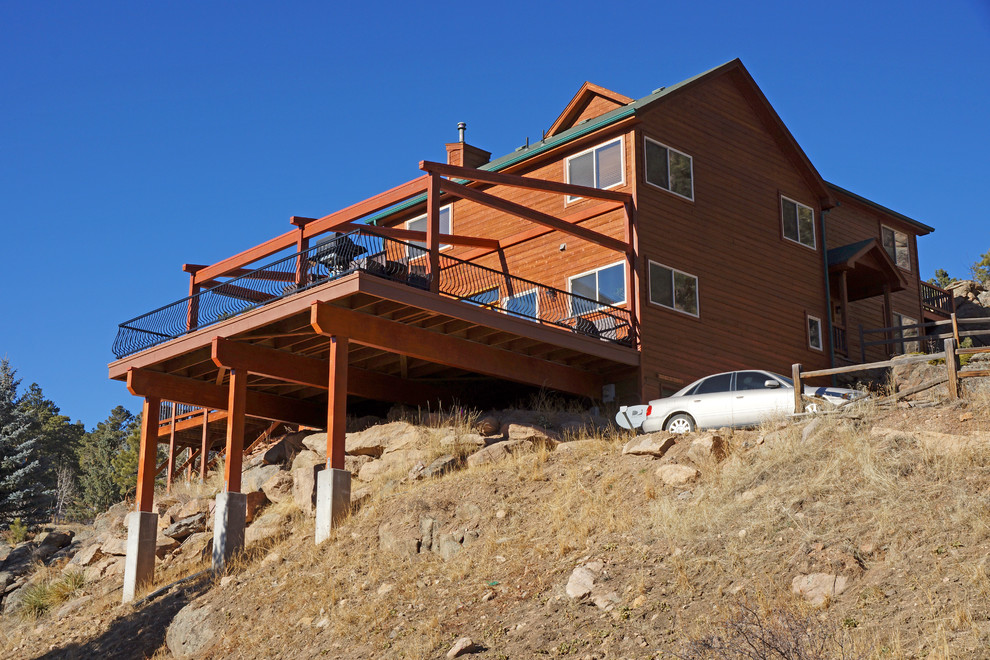 Inspiration for a large rustic deck remodel in Denver with an awning