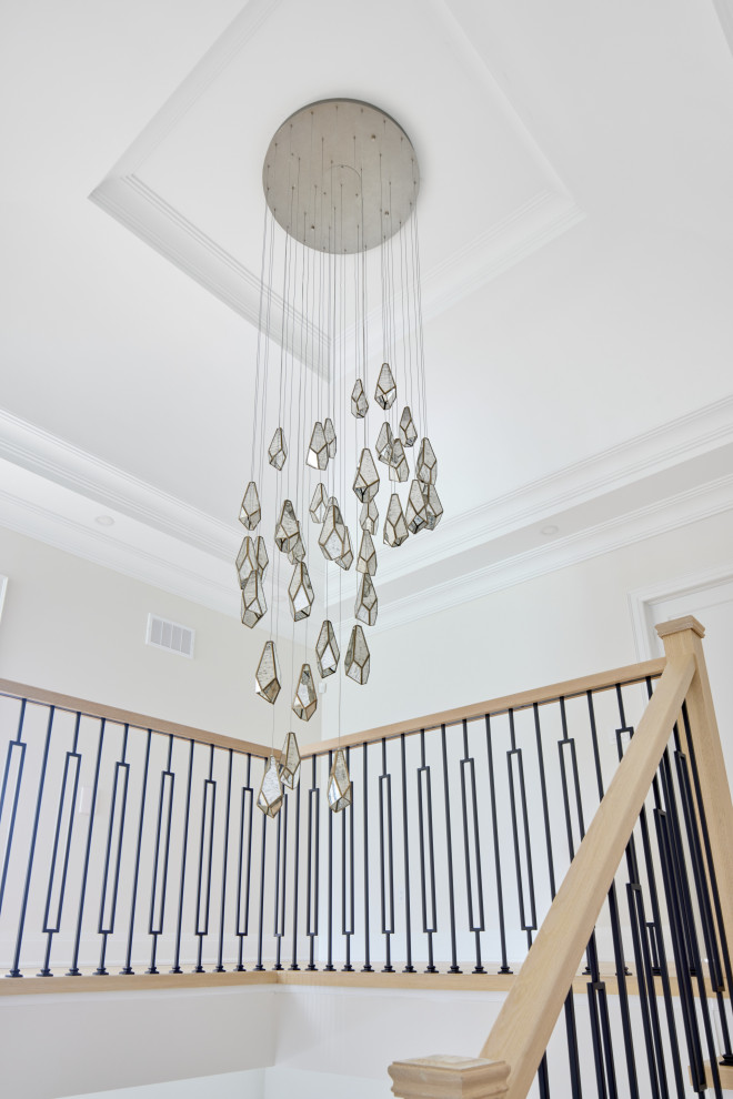 На фото: лестница в стиле неоклассика (современная классика) с деревянными перилами с