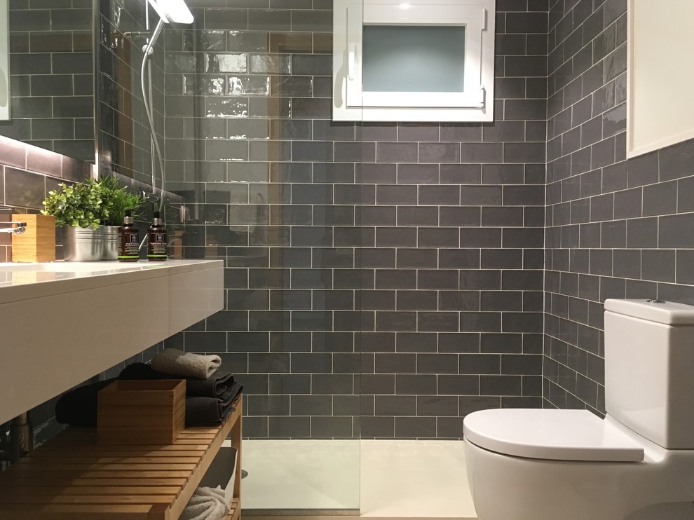 Small transitional master bathroom in Barcelona with a curbless shower, an urinal, gray tile, subway tile, white walls, terrazzo floors, an undermount sink and solid surface benchtops.