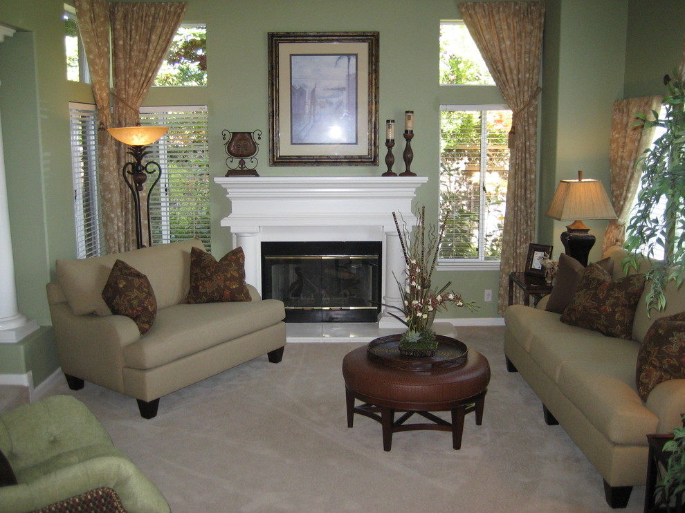Photo of a large tropical open concept living room in San Francisco with green walls, carpet, a standard fireplace and a wood fireplace surround.