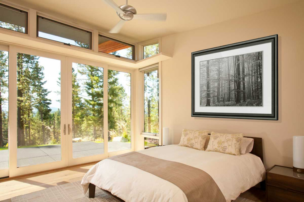 Photo of a contemporary bedroom in Seattle with beige walls, medium hardwood floors and brown floor.