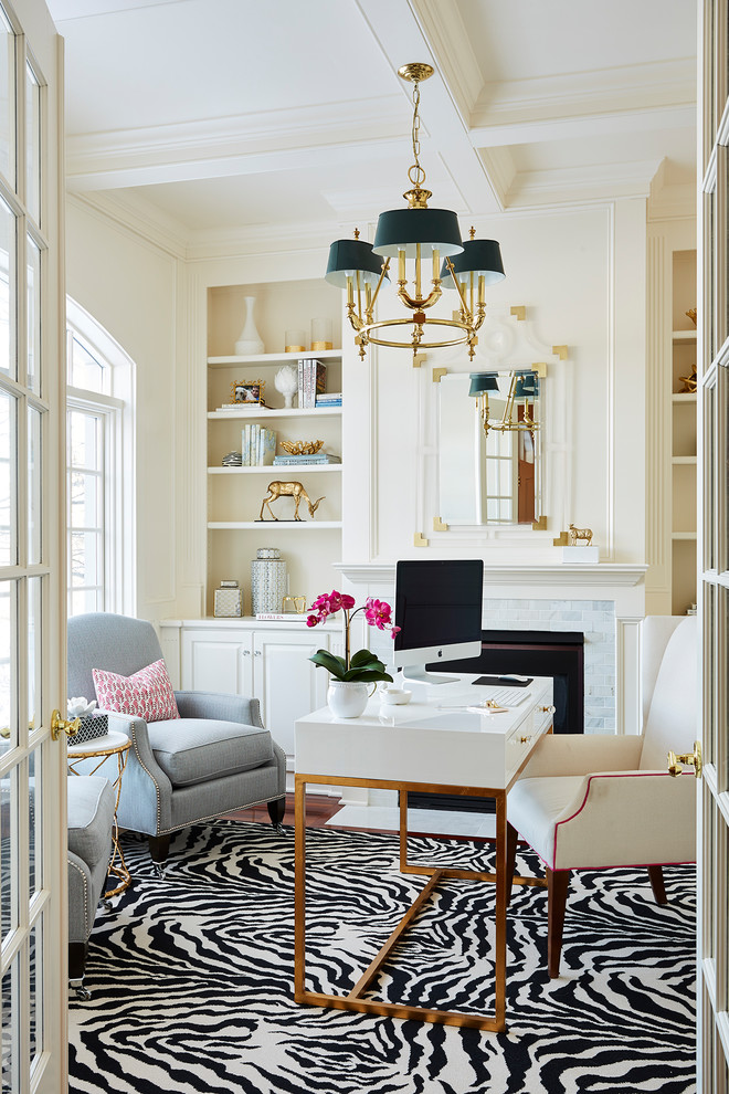 Inspiration for a traditional home office in Minneapolis with beige walls, dark hardwood floors, a standard fireplace, a wood fireplace surround and a freestanding desk.