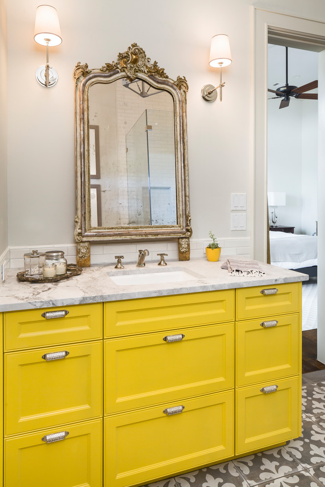 This is an example of a mid-sized transitional kids bathroom in Austin with recessed-panel cabinets, yellow cabinets, white tile, ceramic tile, white walls, porcelain floors, an undermount sink and granite benchtops.