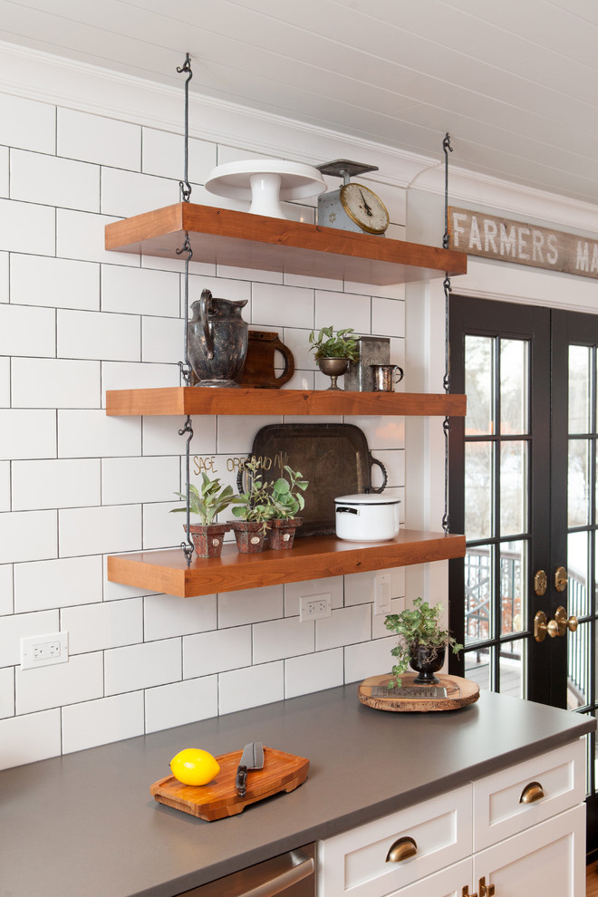 Inspiration for a mid-sized transitional u-shaped eat-in kitchen in Chicago with a farmhouse sink, recessed-panel cabinets, white cabinets, quartz benchtops, multi-coloured splashback, subway tile splashback, stainless steel appliances, light hardwood floors and with island.