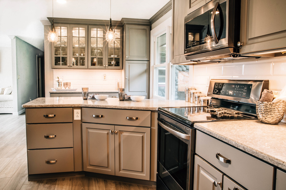 Inspiration for a mid-sized transitional u-shaped medium tone wood floor and brown floor eat-in kitchen remodel with a double-bowl sink, raised-panel cabinets, gray cabinets, granite countertops, white backsplash, ceramic backsplash, stainless steel appliances, a peninsula and gray countertops