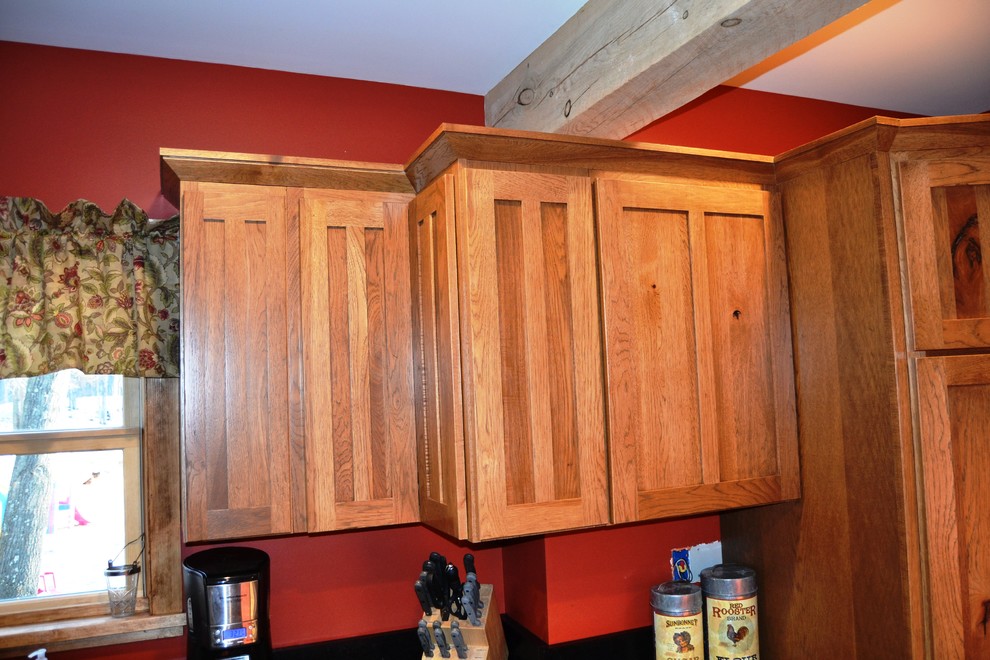 Inspiration for a mid-sized rustic l-shaped slate floor eat-in kitchen remodel in Burlington with an undermount sink, shaker cabinets, distressed cabinets, soapstone countertops, stainless steel appliances and a peninsula