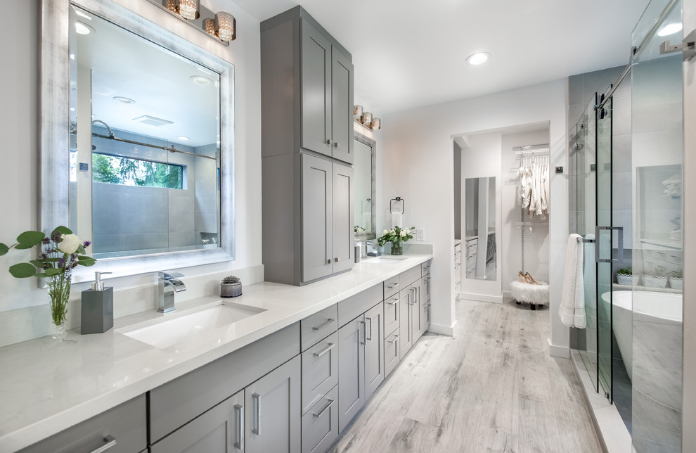 Inspiration for a mid-sized transitional master gray tile and porcelain tile porcelain tile freestanding bathtub remodel in Seattle with shaker cabinets, gray cabinets, a two-piece toilet, white walls, an undermount sink and quartzite countertops