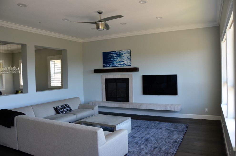 This is an example of a large transitional open concept family room in San Francisco with grey walls, dark hardwood floors, a standard fireplace, a stone fireplace surround and a wall-mounted tv.