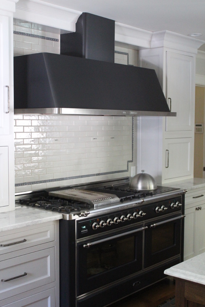 Eat-in kitchen - large transitional u-shaped medium tone wood floor eat-in kitchen idea in New York with a double-bowl sink, recessed-panel cabinets, dark wood cabinets, granite countertops, blue backsplash, subway tile backsplash, black appliances and an island
